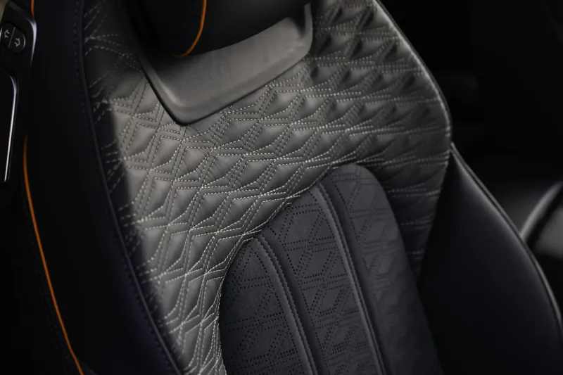 Close-up of quilted gray leather seat with orange accents in Bentley Continental GT interior
