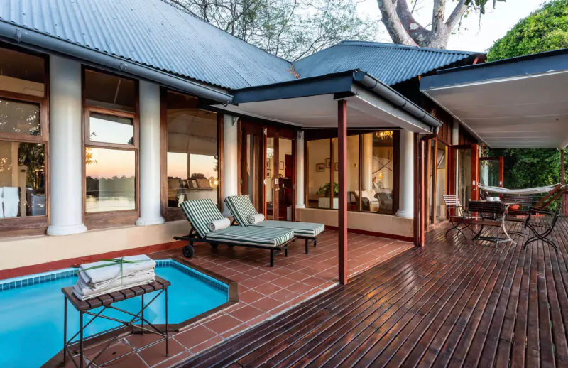 Luxury lodge deck at The River Club in Zambia with pool, loungers, sunset river view