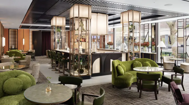 Elegant Nobu Hotel Marylebone lobby with green velvet seating, bar, and plants under modern lighting.