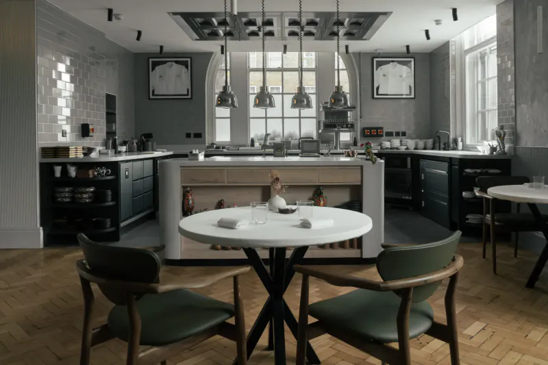 Modern kitchen interior with central white round table, green chairs, pendant lights, and large arched windows