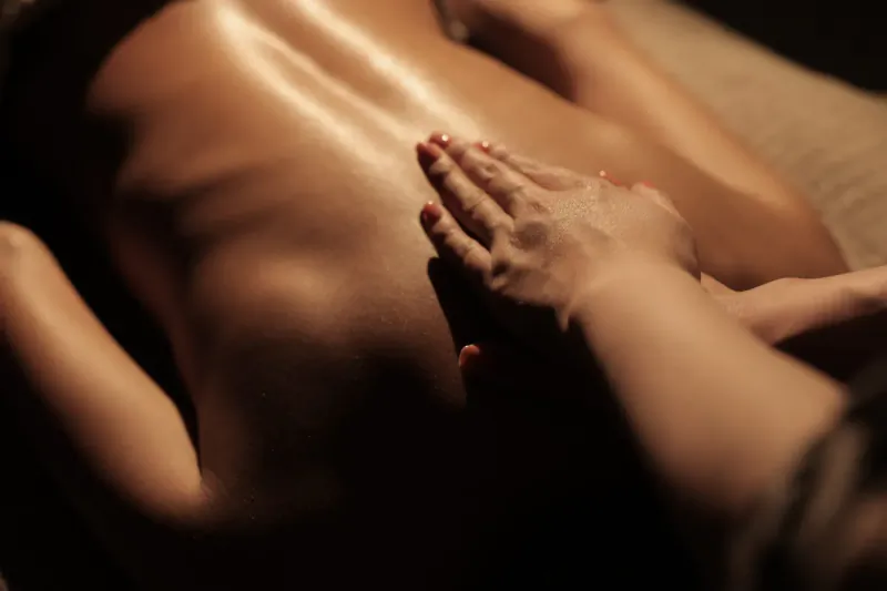 Close-up of hands massaging a woman's bare back in a luxury wellness spa