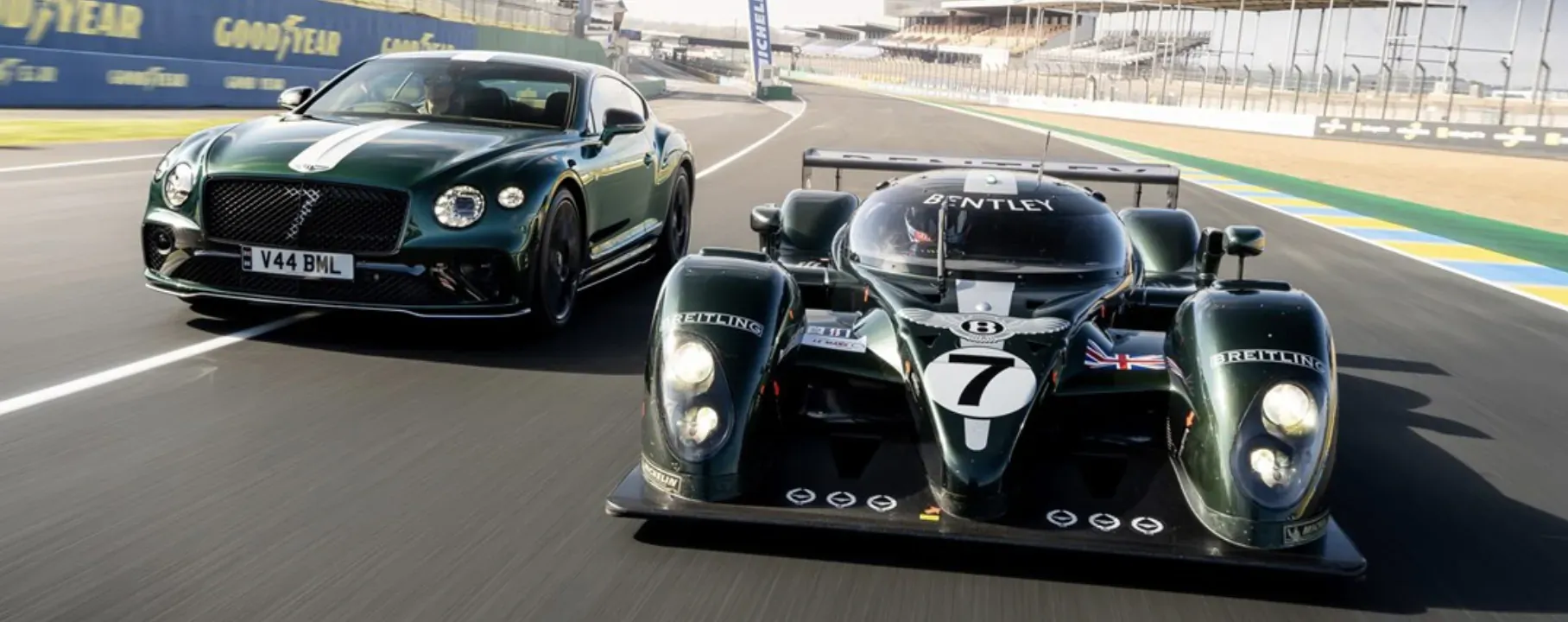 Bentley #7 race car overtakes green Bentley road car on Le Mans track with barriers.
