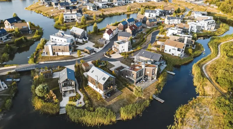 Aerial view of Luxuria modern waterfront homes on Silverlake Dorset, surrounded by rivers and greenery.