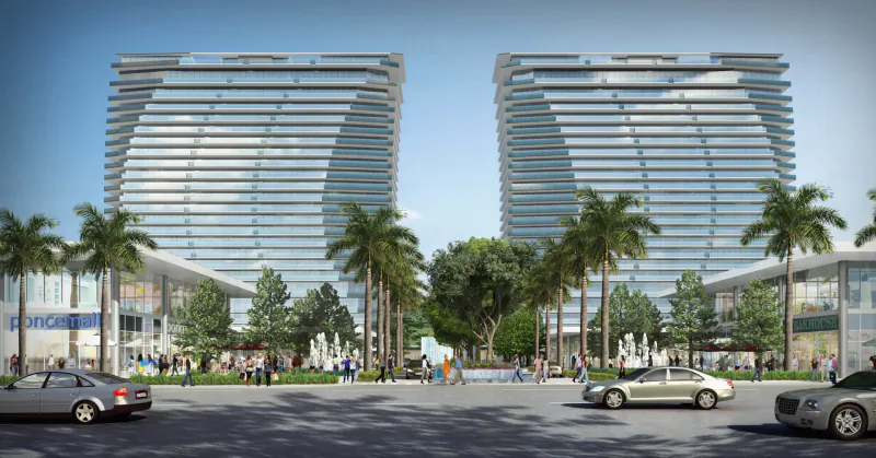 Oasis Hallandale luxury mixed-use development: twin curved glass high-rises, palm trees, cars, and people in sunny plaza.
