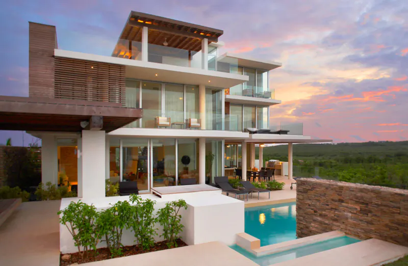 Modern multi-level luxury home with infinity pool, terrace, and lush greenery at sunset, Àni Private Resorts gallery