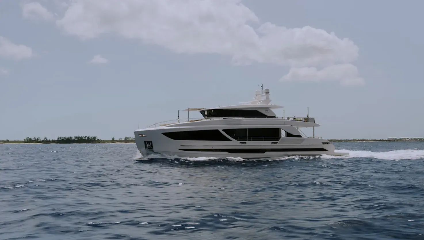 White multi-deck superyacht cruising on calm ocean waters under partly cloudy sky