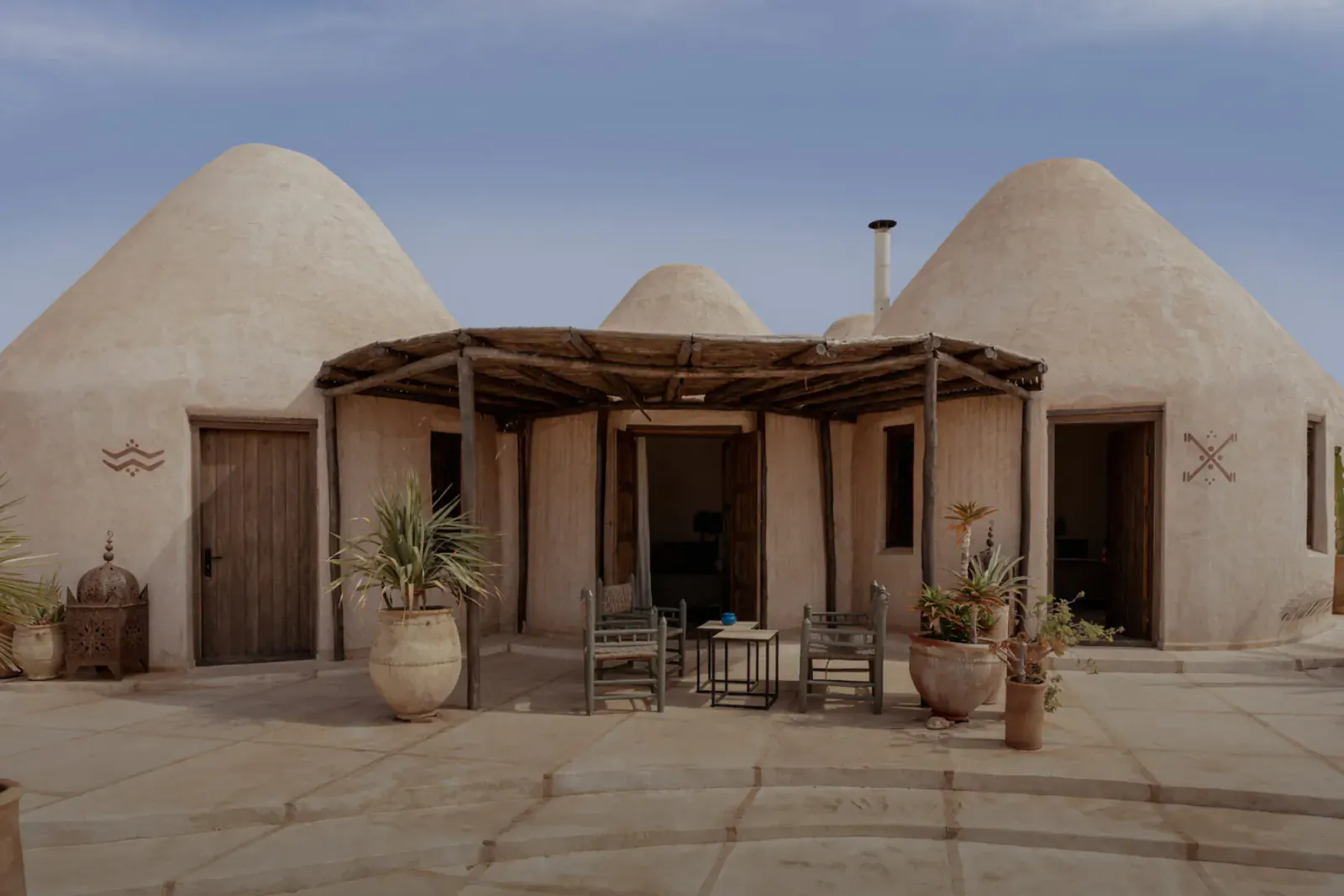 Les Jardins De Villa Maroc: Adobe dome huts with courtyard, chairs, table, plants, and lanterns in Essaouira.