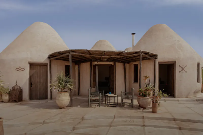 Les Jardins De Villa Maroc: Adobe dome huts with courtyard, chairs, table, plants, and lanterns in Essaouira.