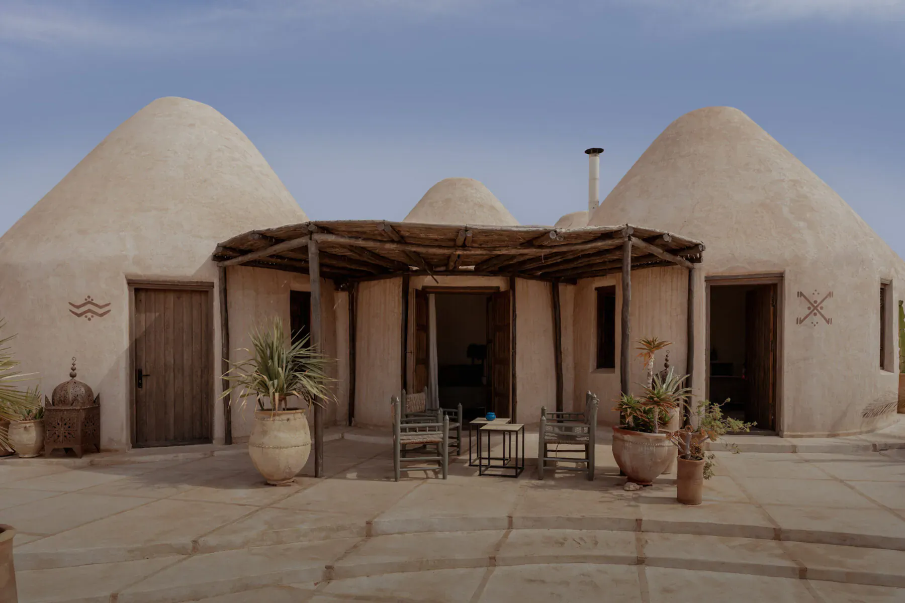 Les Jardins De Villa Maroc: Adobe dome huts with courtyard, chairs, table, plants, and lanterns in Essaouira.