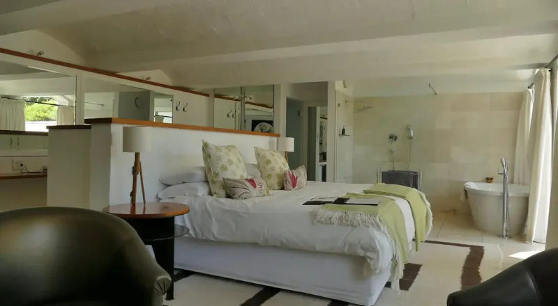 Spacious luxury bedroom at South Hill Vineyards with king bed, freestanding tub, and garden view