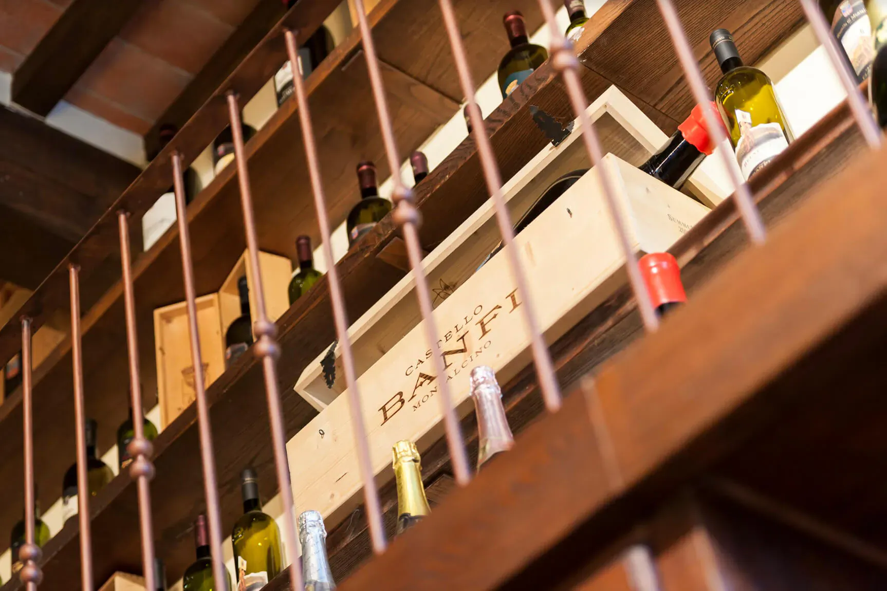 Close-up of Banfi wine bottles and wooden crates on wooden shelves in Tuscany wine cellar