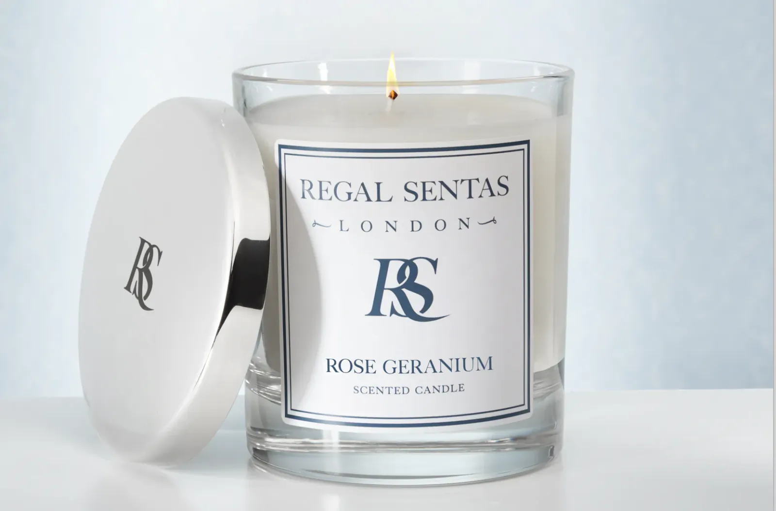 Regal Sentas London Rose Geranium scented candle in glass jar with lit wick and white lid