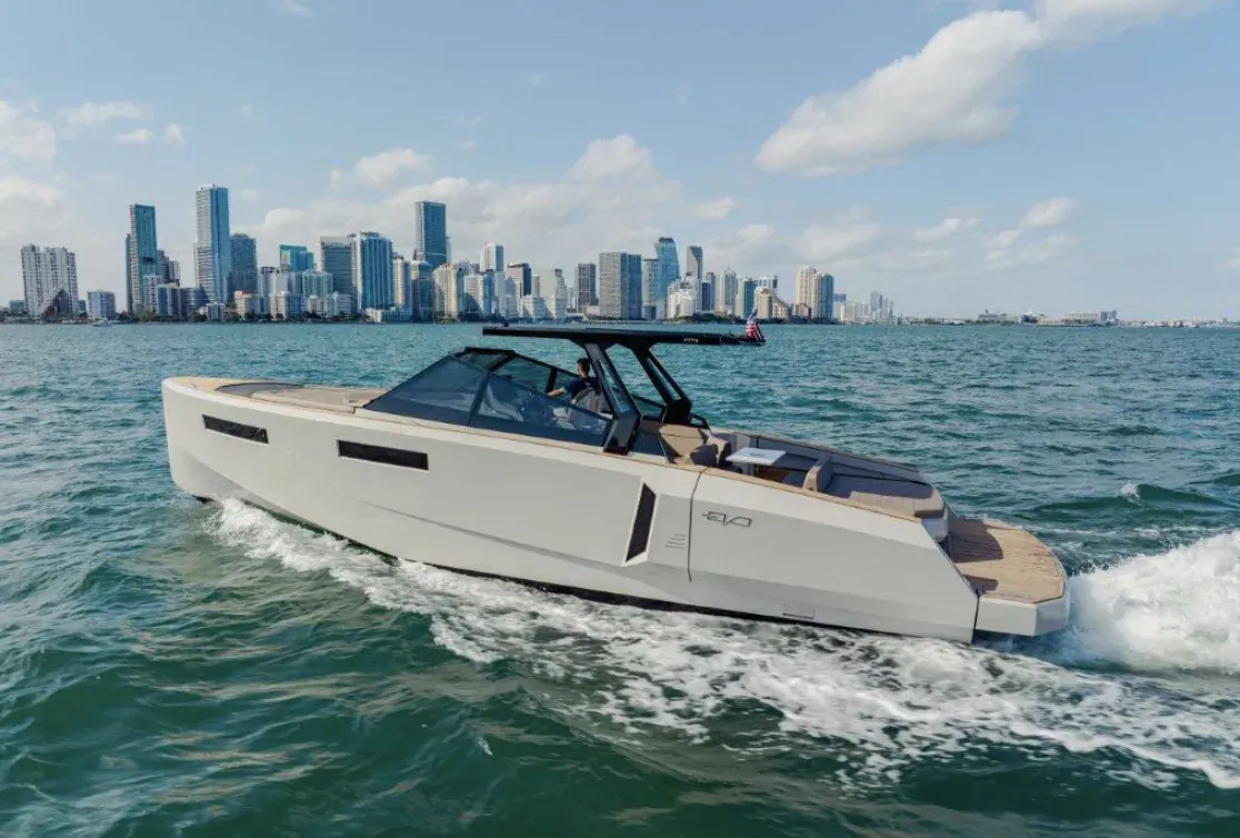 White Evo R4 WA yacht speeding on water toward Miami skyline at Palm Beach Boat Show
