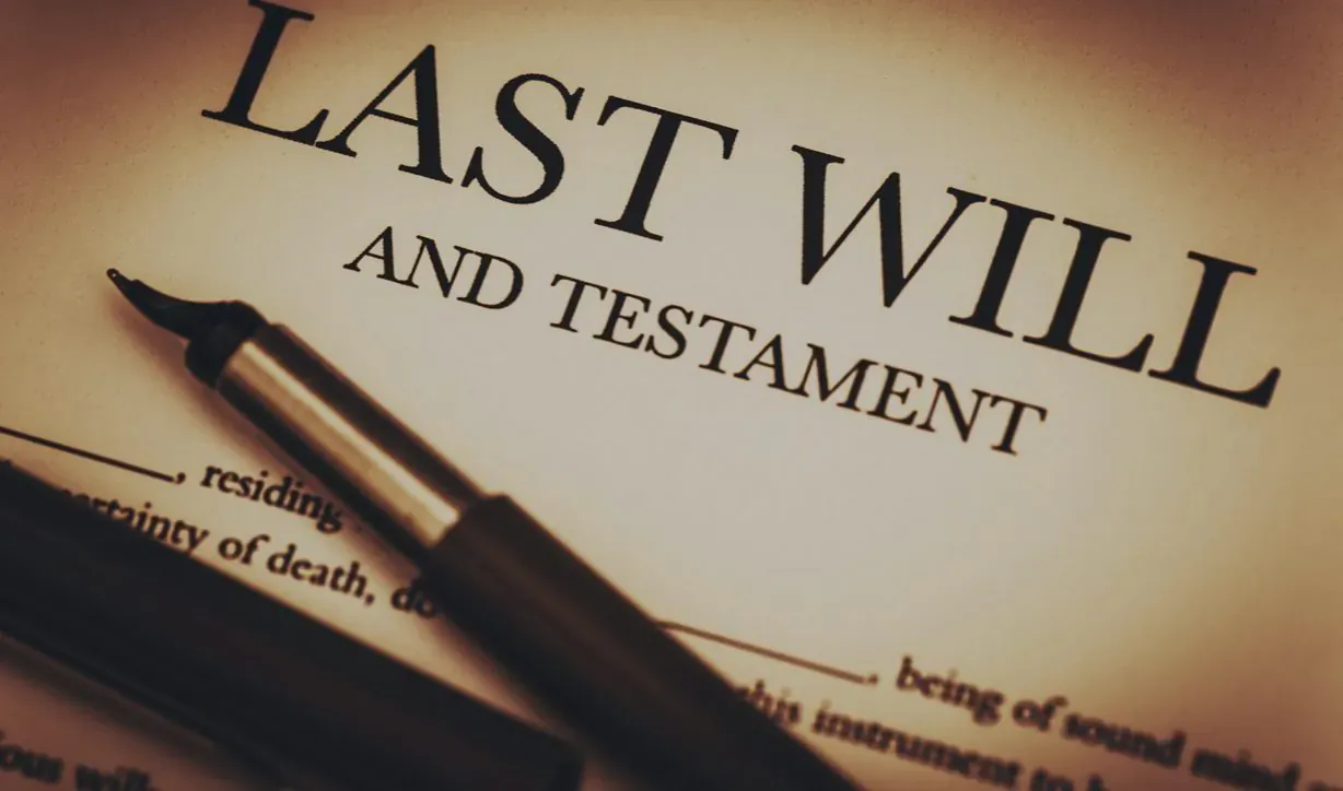 Close-up of open 'Last Will and Testament' document with black fountain pen resting on it