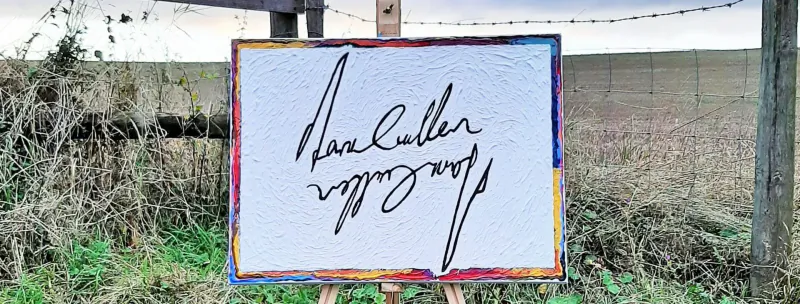 White canvas on easel outdoors with 'Dan Cutler' signature, colorful frame, barbed wire fence behind.