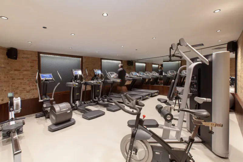 Spacious modern gym at Taj 51 Buckingham Gate with treadmills, ellipticals, bikes, and weight machines.
