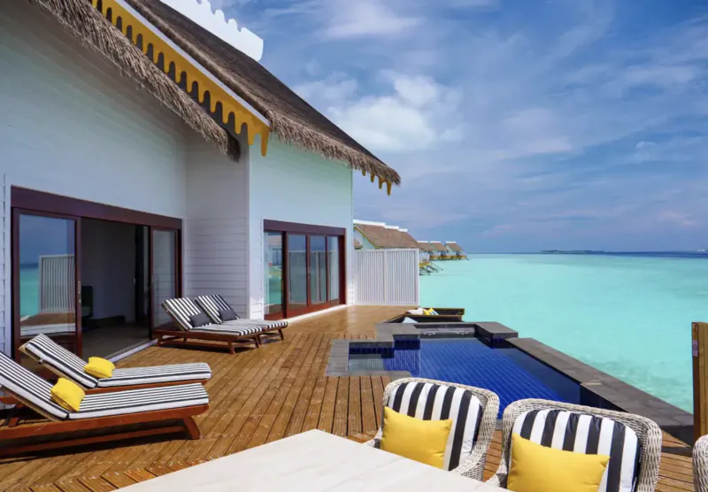 SAII Maldives luxury overwater villa with infinity pool, lounge chairs, and turquoise lagoon view