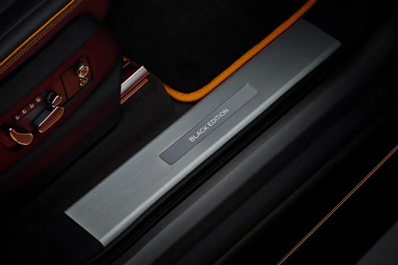 Bentley Black Edition illuminated door sill with 'Black Edition' text, orange accents, luxury car interior.