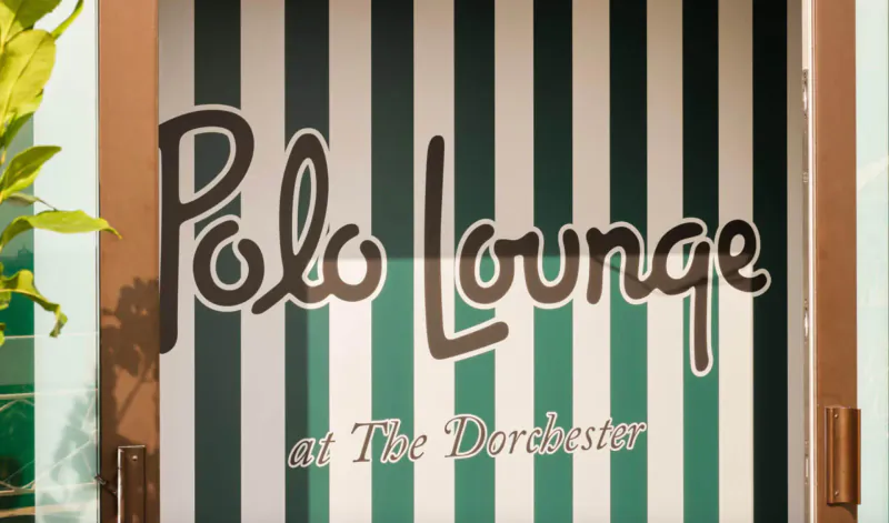 Polo Lounge at The Dorchester entrance with green and white striped awning and plants