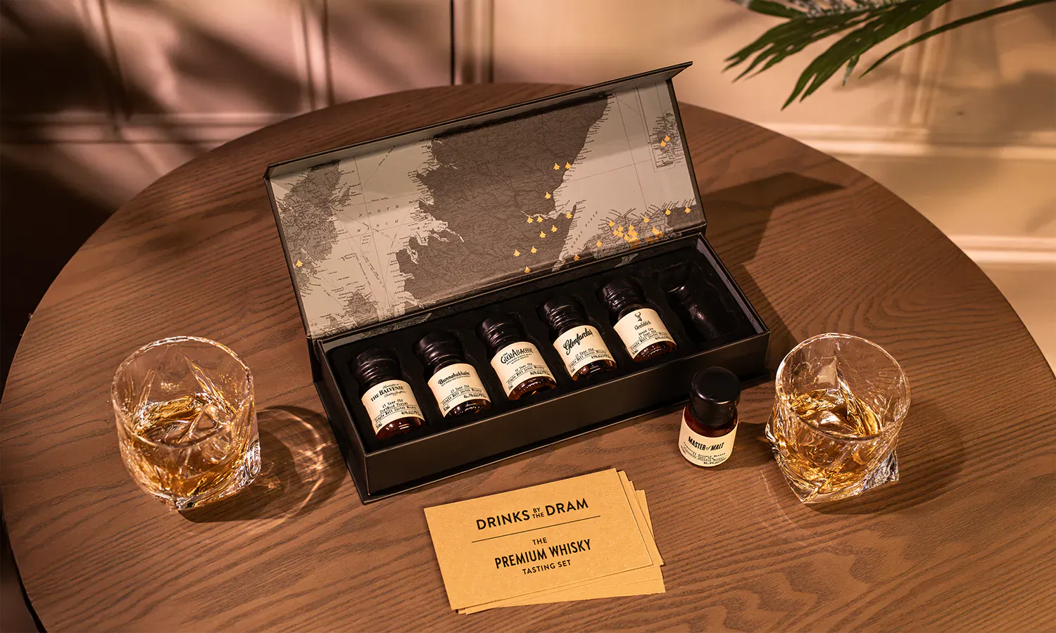 Open Drinks by the Dram Premium Whisky Set box with 6 small whisky bottles on wooden table with glasses and Father's Day card