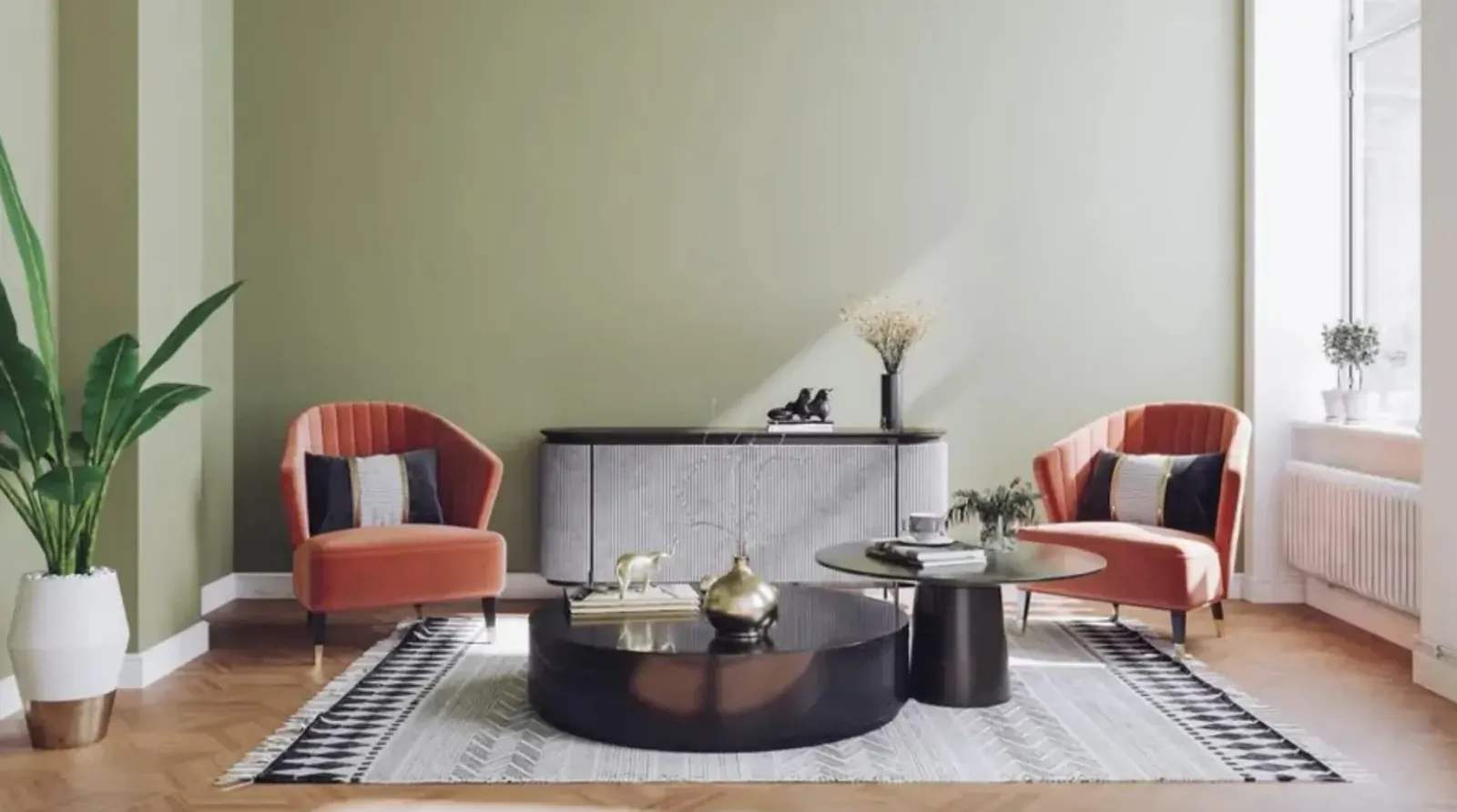 Modern living room with two orange velvet armchairs, black round coffee table on gray rug, green walls, plants