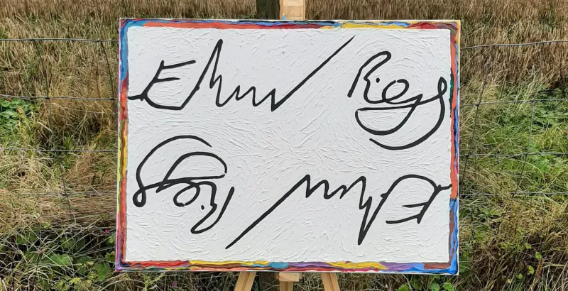 Handwritten 'Emmy/Ross' and 'Sky/Matt' signatures on white canvas in colorful frame on easel amid grass, Signed99 gallery art.