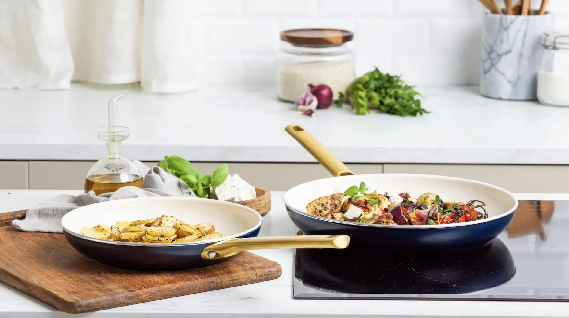 Padova frying pan collection: navy pans with pasta and tomato veggie dish on kitchen counter.