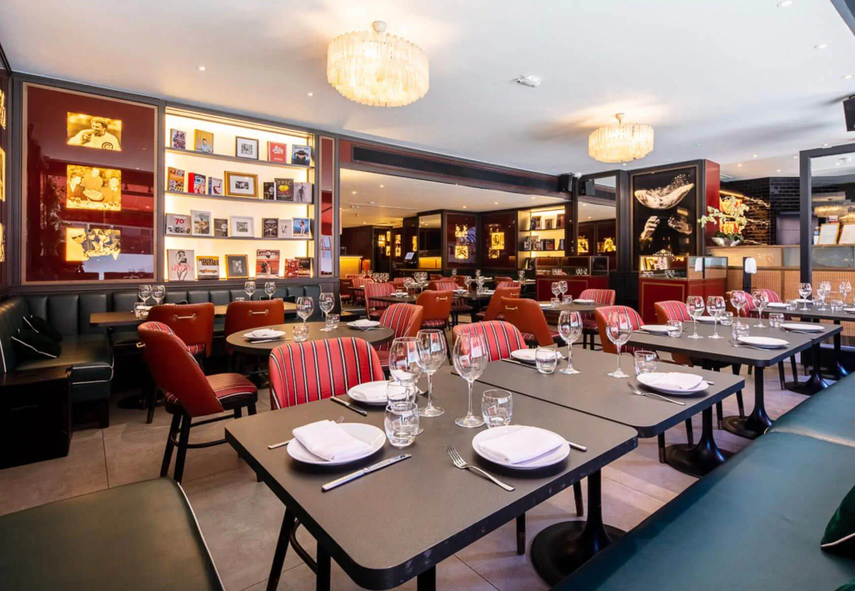 Crazy Pizza Marylebone: elegant Italian restaurant interior with red chairs, set tables, bookshelves, and chandeliers