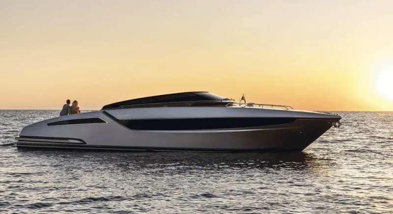 White Ferretti Yachts 720 luxury motor yacht with two people aboard, sleek design on ocean at sunset.