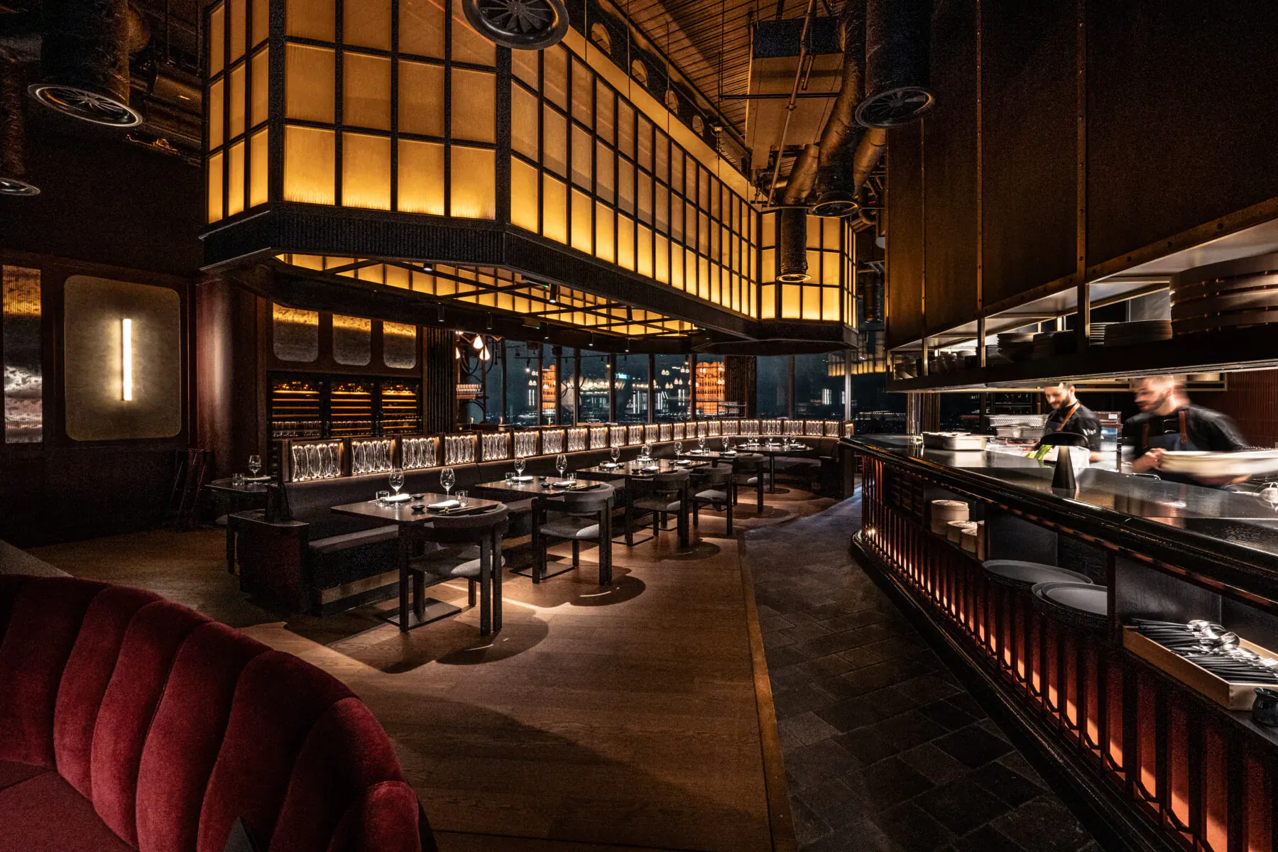 Lucky Cat by Gordon Ramsay: Luxurious Asian restaurant interior with glowing lattice walls, wooden tables, red velvet chairs, and chefs at sushi counter.