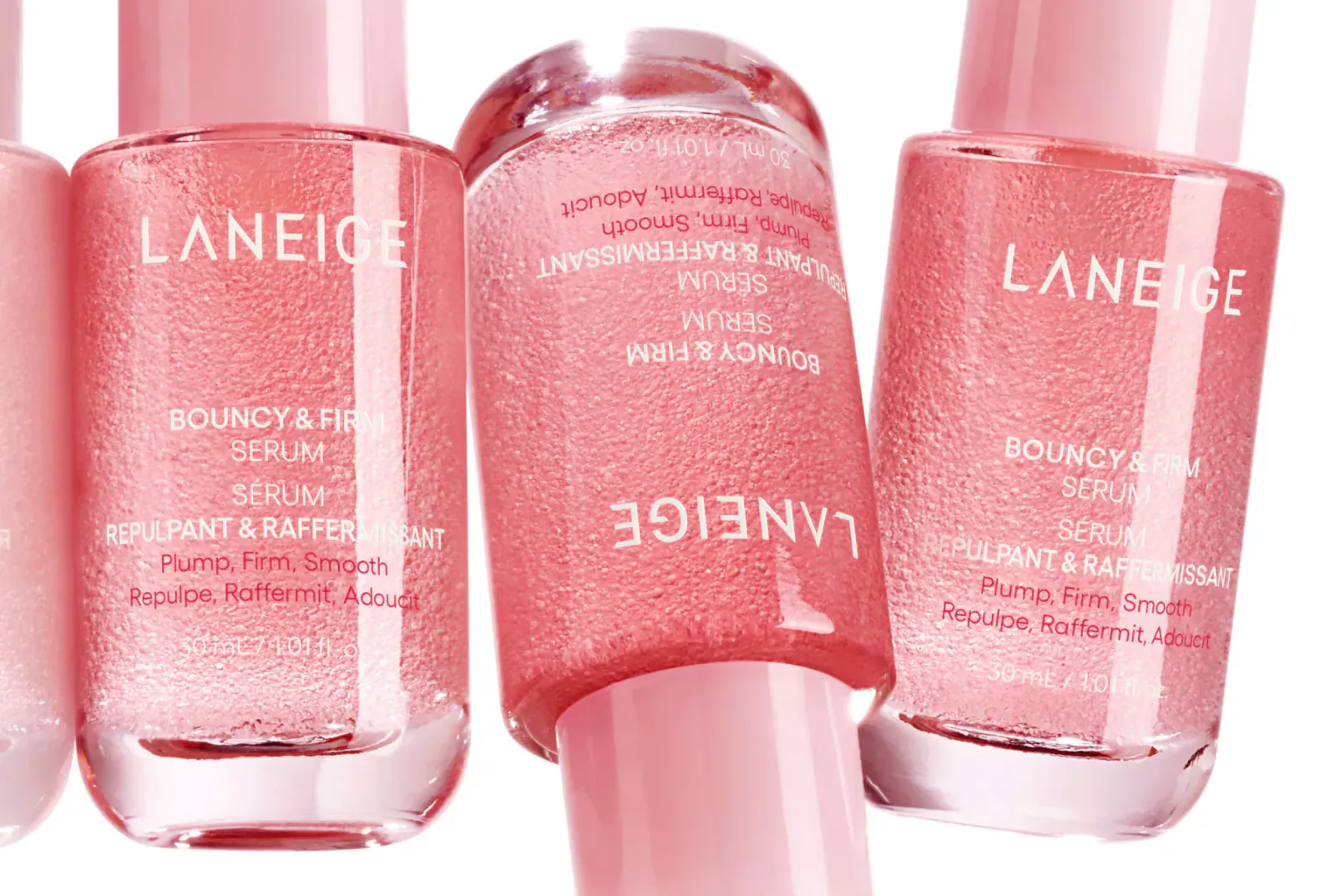 Multiple bottles of LANEIGE Bouncy & Firm Serum and Pore Firming Serum in pink, glossy packaging.