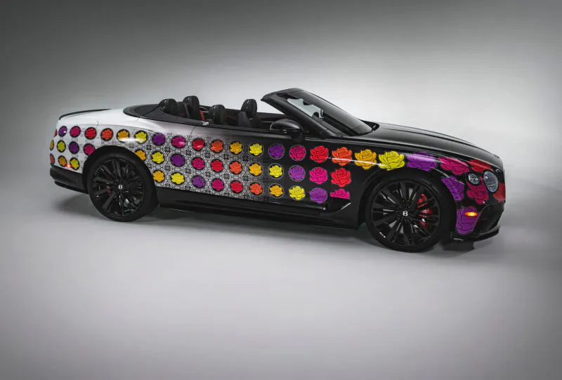 Bentley convertible with vibrant multicolored polka dot and floral side pattern, black wheels, side view