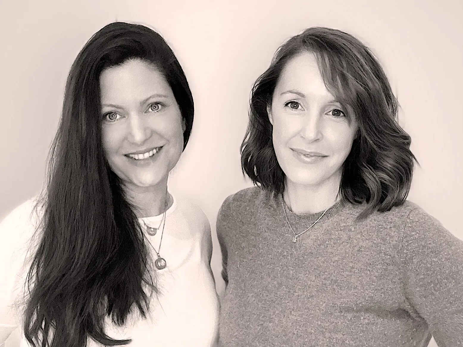 Zoe and Charlie, co-founders of Found Clean Beauty, smiling side by side in sepia portrait