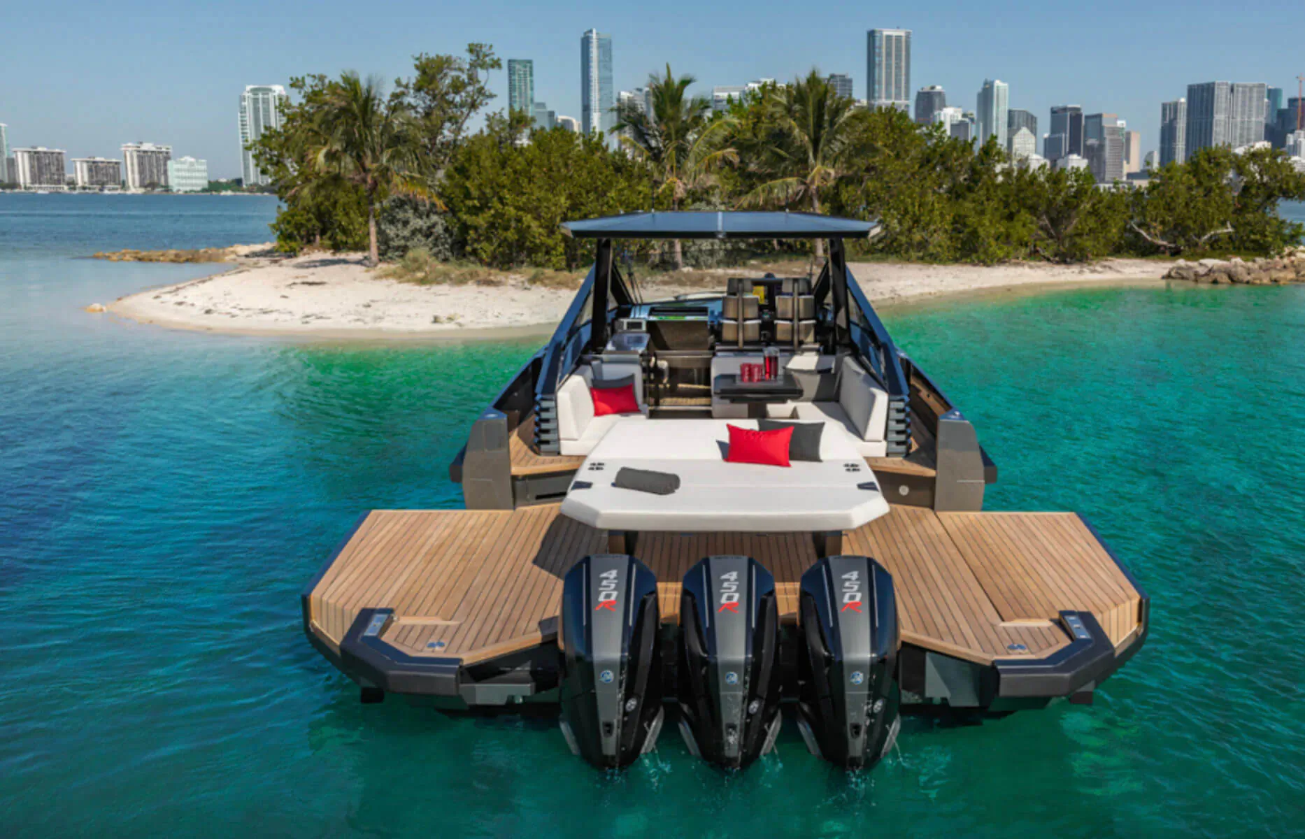 43 Wallytender X luxury yacht with red cushions and four outboard motors anchored in turquoise water near Miami skyline and palms