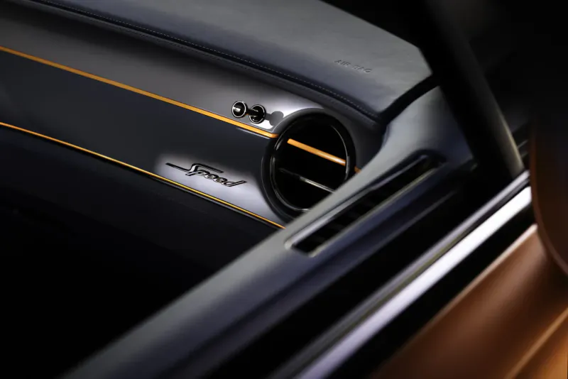 Bentley Continental GT Speed dashboard close-up: 'GT Speed' badge and open air vent with orange trim.