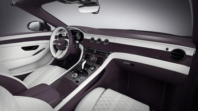 Luxurious purple and white interior of Bentley Continental GTC Speed convertible, showcasing leather seats, steering wheel, and dashboard.