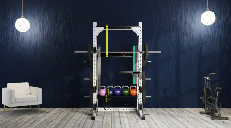 Modern home gym with Eleiko power rack loaded with colorful kettlebells and barbell, yellow Öppen collars, white armchair, exercise bike, navy walls.