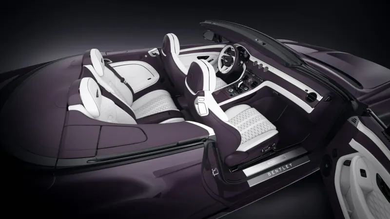Purple Bentley Continental GTC Speed convertible interior with white leather seats, open doors showing 'Bentayga' sill, top down.