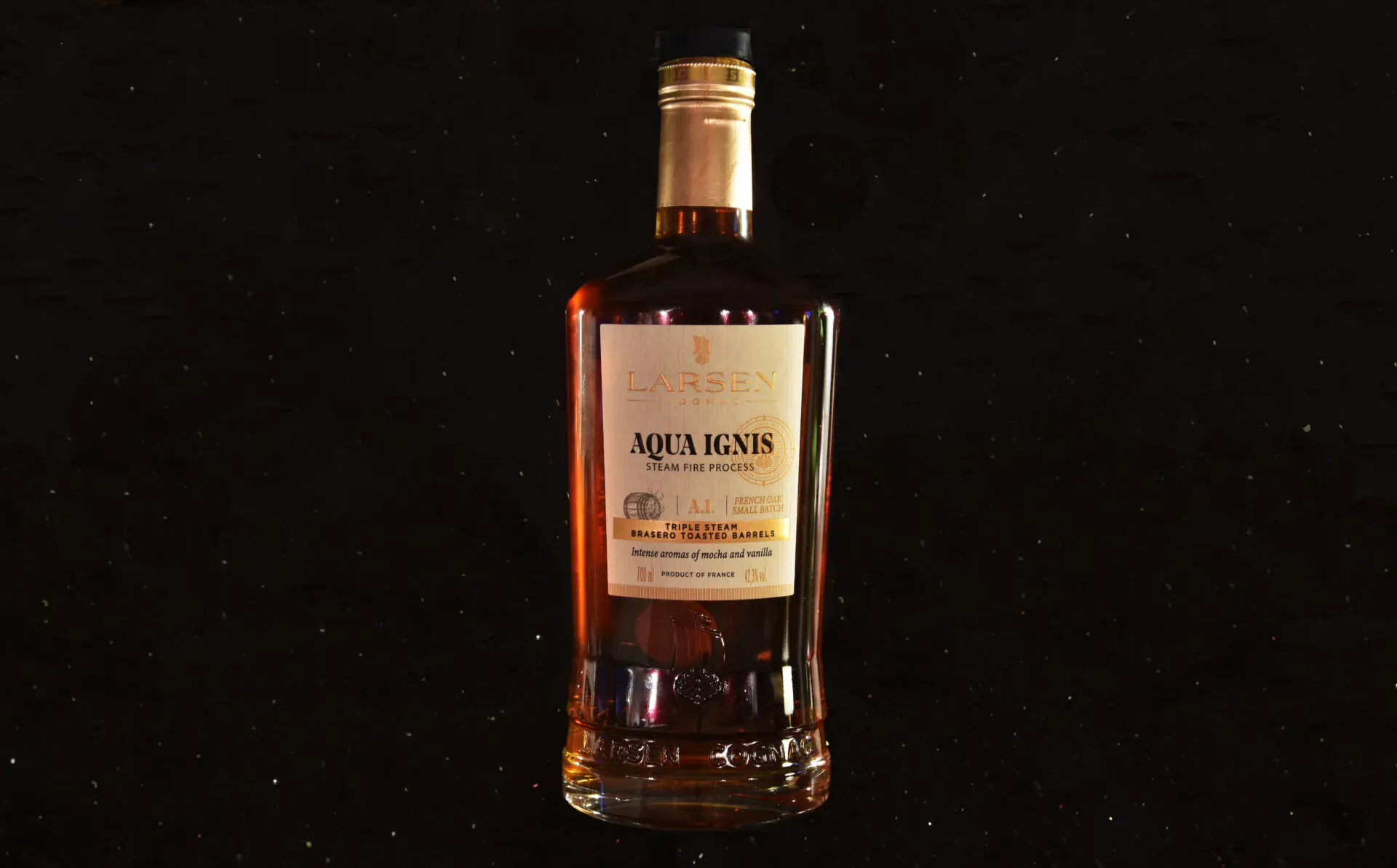 Aqua Regis amber liquor bottle with gold cap on black background, labeled 'Aqua Regis'.