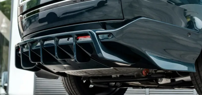 Close-up of Racing Green Automotive SUV's sleek black rear diffuser with red accents and quad exhausts