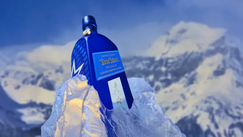 Blue 'Blue Label' vodka bottle on ice with snowy mountains backdrop