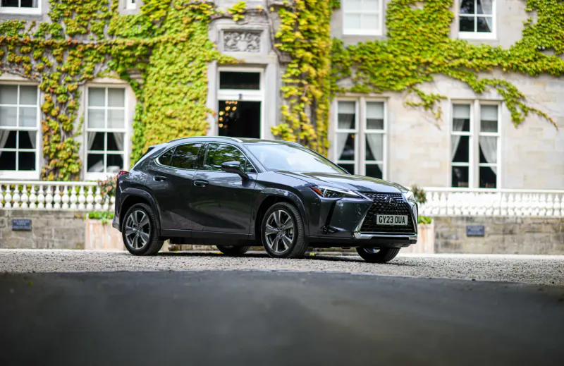 Black Lexus NX SUV parked in front of ivy-covered historic building at Virgin Hotel, Edinburgh.