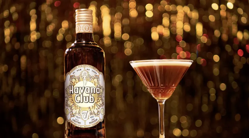 Havana Club limited-edition bottle with ornate label beside a martini glass, festive bokeh backdrop