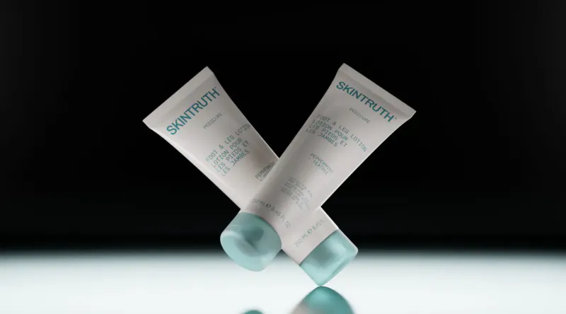 Two Skintruth facial care tubes crossed on reflective surface, Salvation! for winter targeted care.