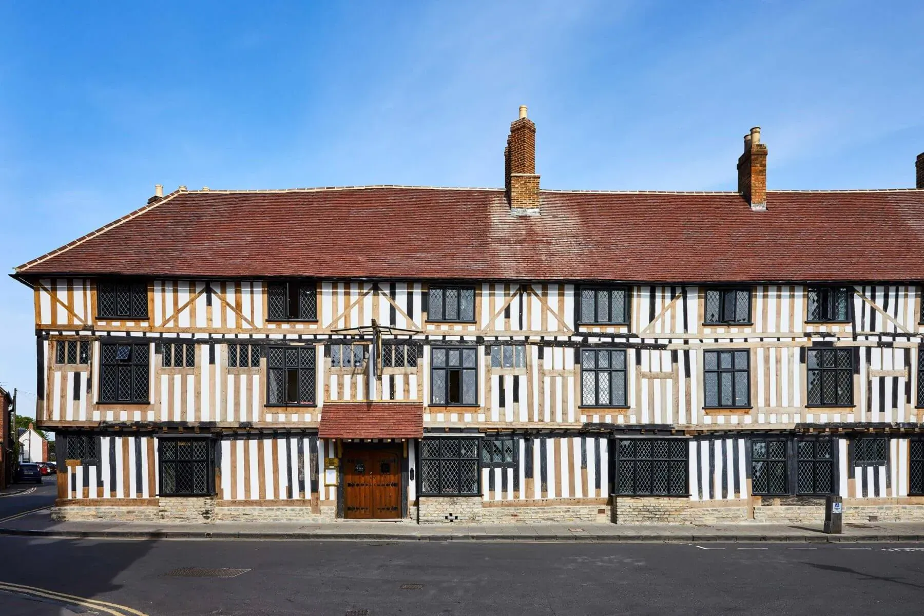 Hotel Indigo Stratford upon Avon, historic timber-framed building with red-tiled roof and wooden door on street.
