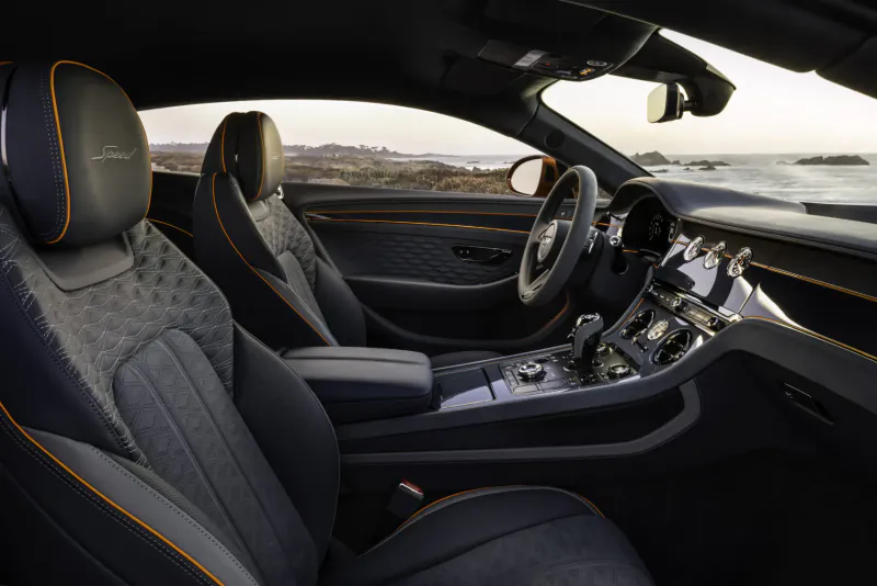 Bentley Continental GT Speed interior with quilted leather seats, steering wheel, dashboard, overlooking ocean at sunset.