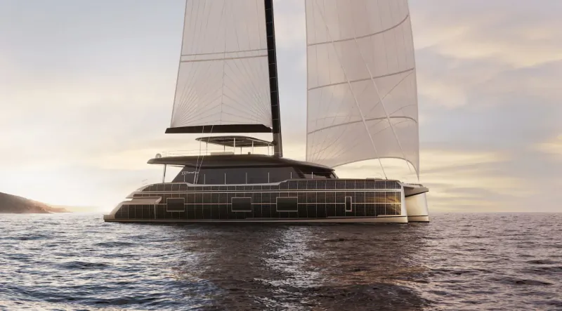 Sunreef 100 ECO luxury catamaran sailing on sea at sunset with billowing white sails and distant island