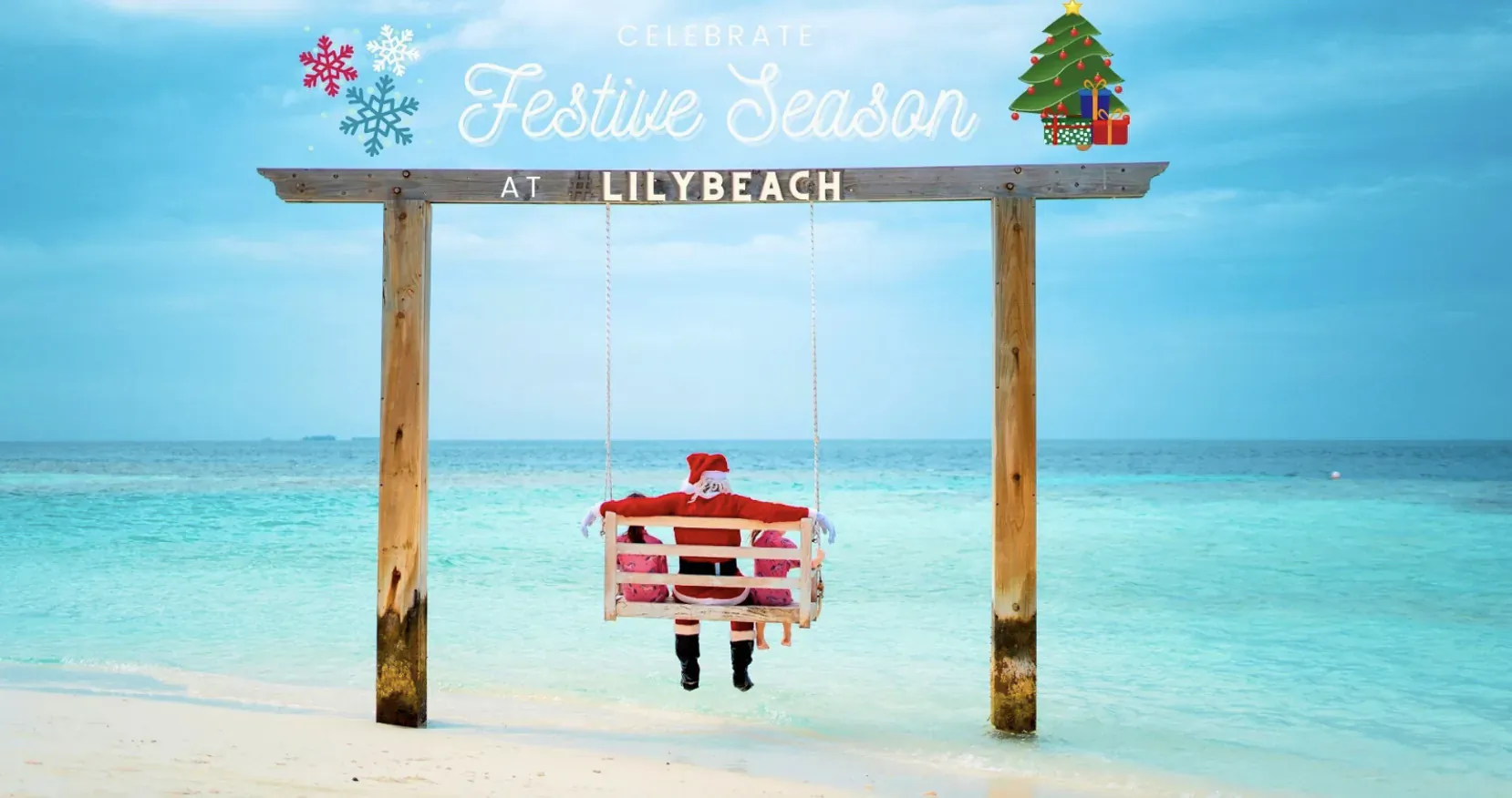 Santa swinging on hammock under 'Festive Season at Lily Beach' sign on tropical beach with turquoise sea.