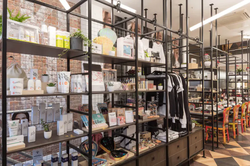 Young LDN Medispa gallery in Notting Hill: black metal shelves with skincare products, books, plants against brick wall