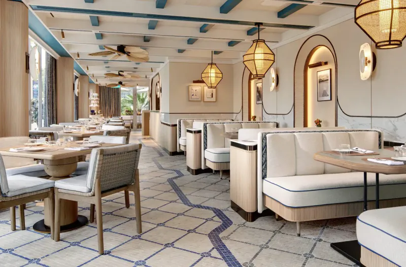 Elegant Paiza Collection dining room at Marina Bay Sands with teal ceilings, pendant lamps, white booths, and tiled floors.